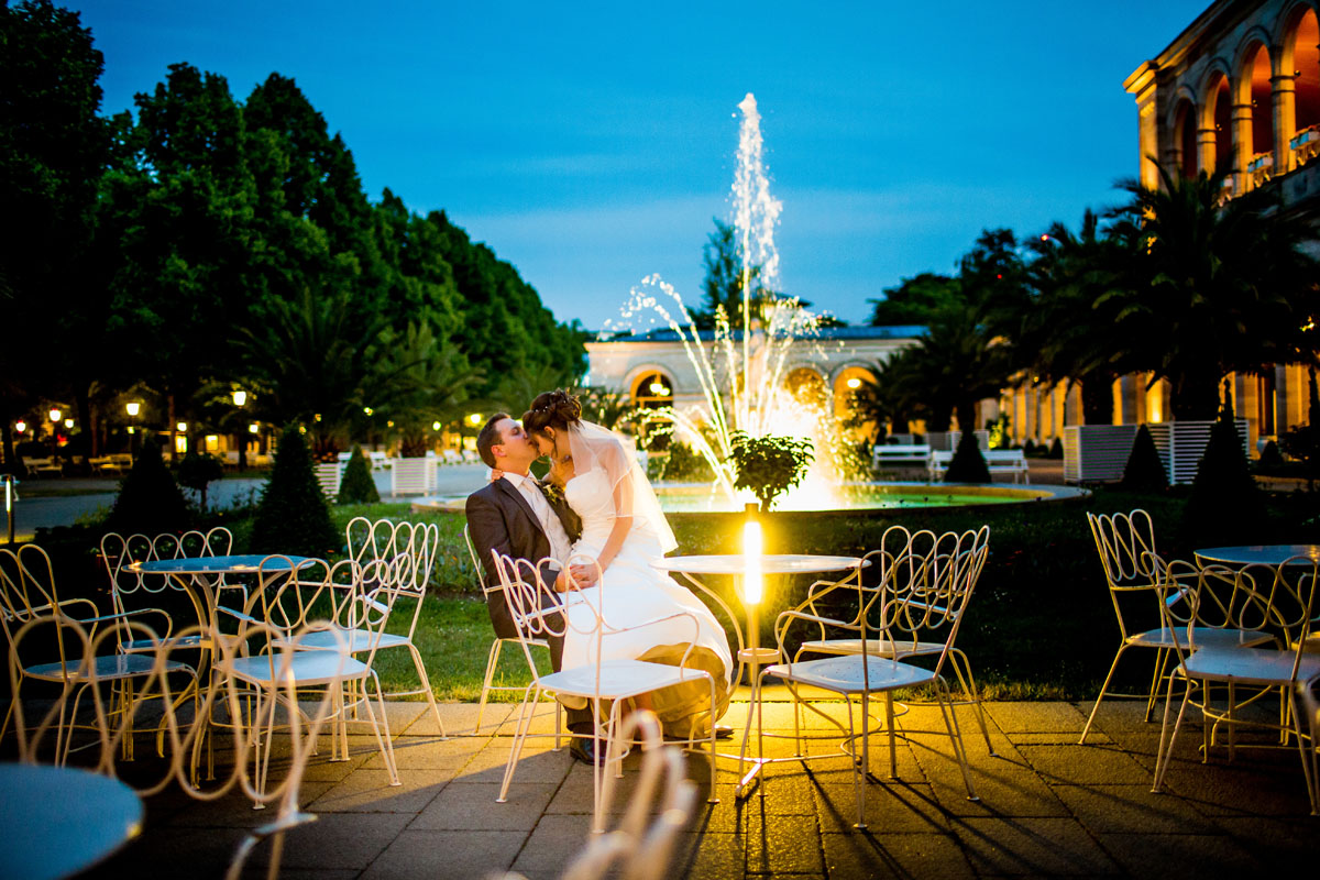 Verliebtes Brautpaar vor dem Brunnen des Kurgarten Cafes